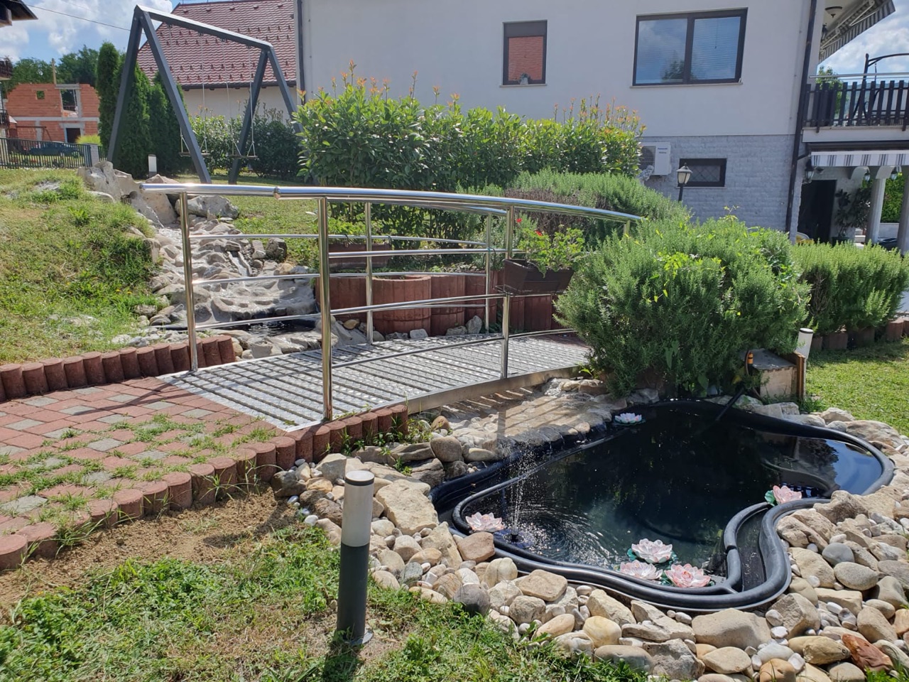 Uređeno dvorište s ljuljačkom, ribnjakom i mostićem